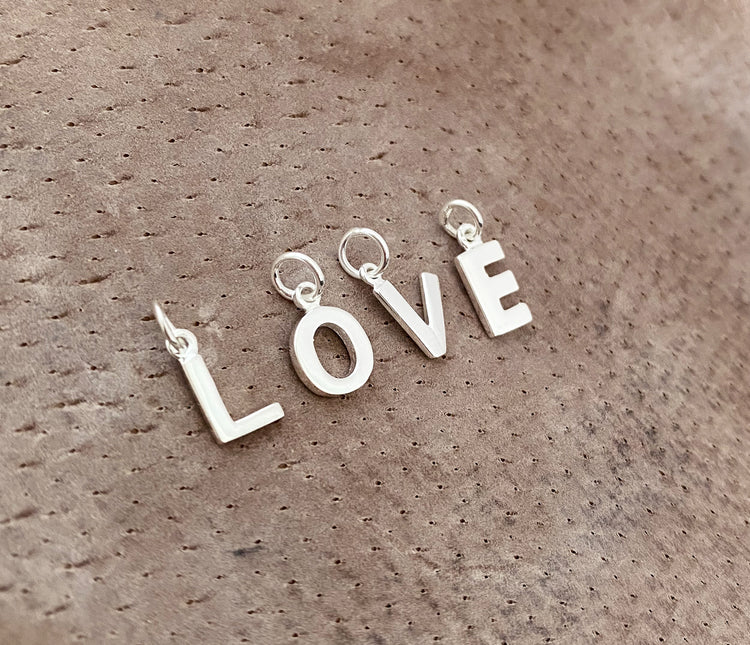 Bokstavsberlocker i silver som skapar ordet LOVE