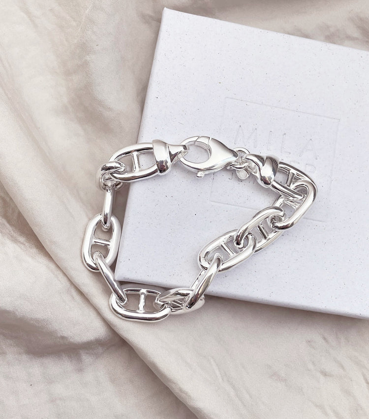 Armband med silverkedja som ligger på en vit presentask.