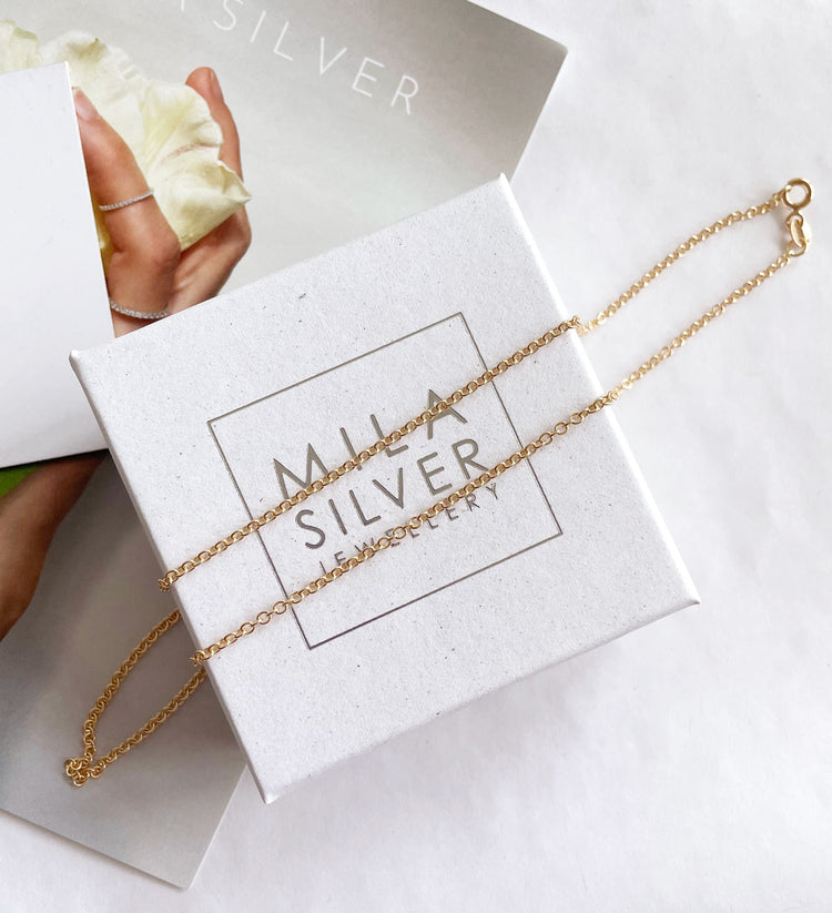 guldkedja som ligger på en ask från Mila Silver.