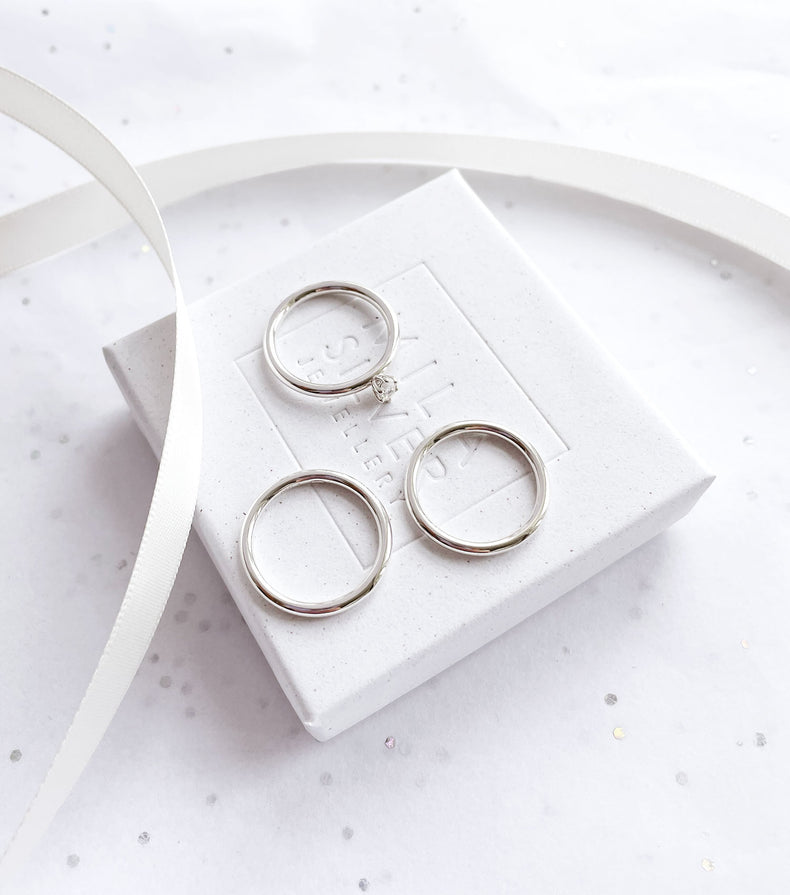 Tre silverringar placerade på en vit ask från Mila Silver.