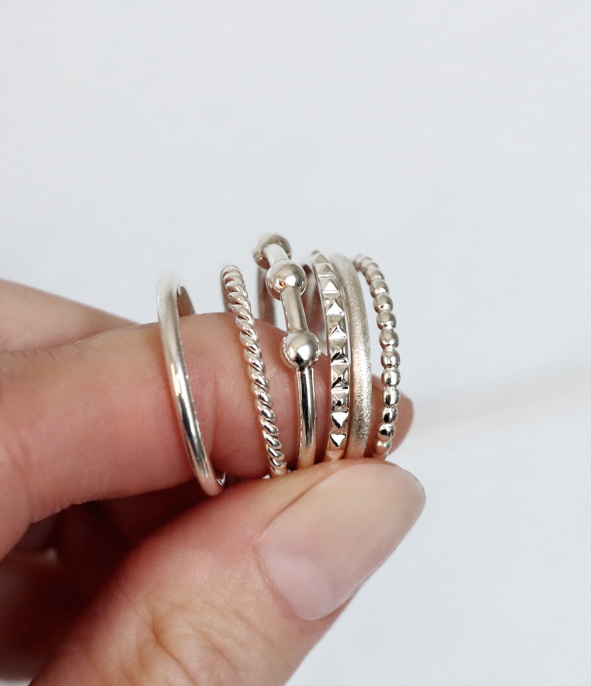 Sex smala silverringar med olika ytor i kombination. Blank, vriden, kulring,nitar, matt.