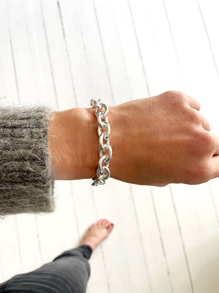 Tjej som bär ett silverarmband med bred kedja i äkta silver.