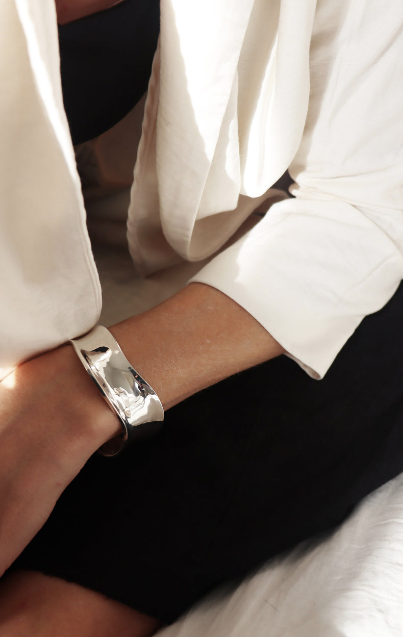 Tjej som bär ett brett stelt armband i äkta silver