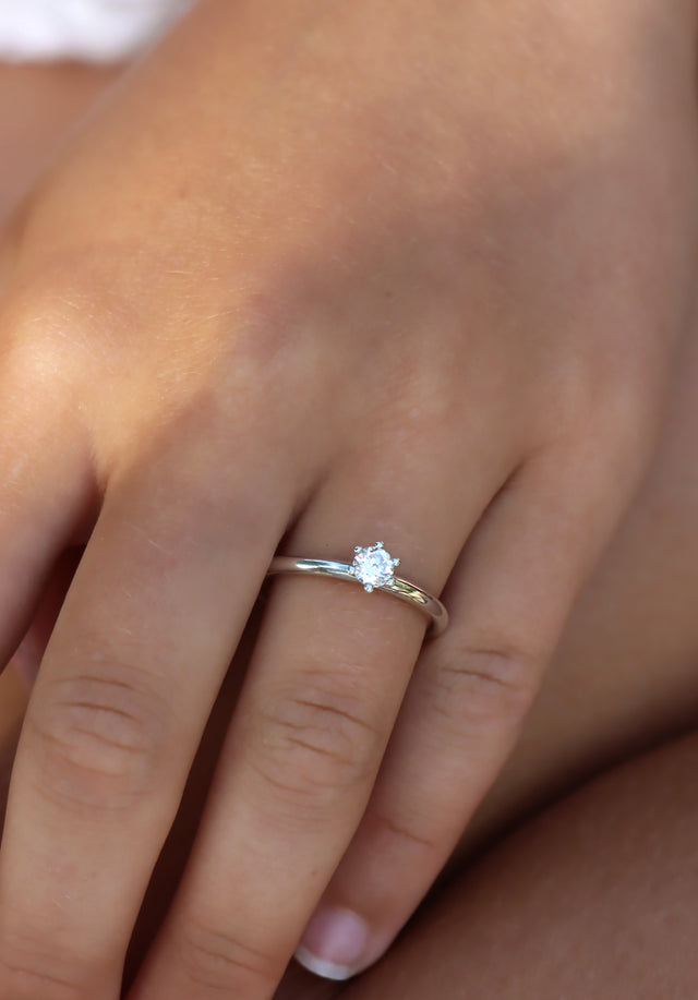 Tjej som bär en vigsel- eller förlovningsring med 0,25 ct briljantslipad diamant.