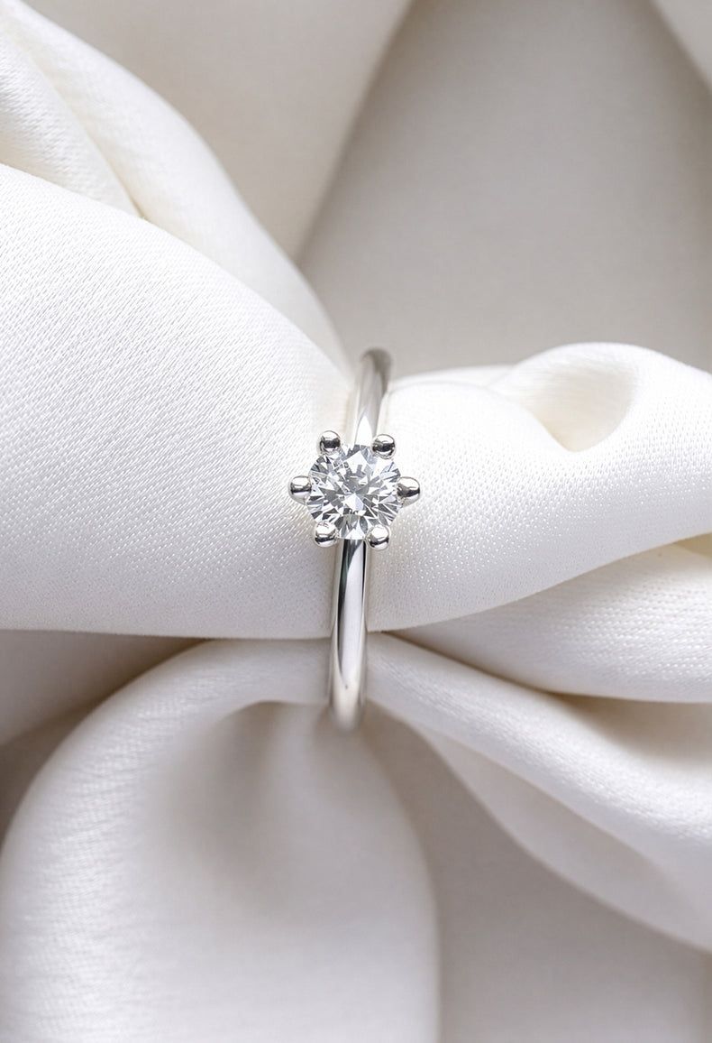 Diamantring i silver med rund briljantslipad diamant 0,5 ct. Ringen är placerad runt ett vitt tyg.