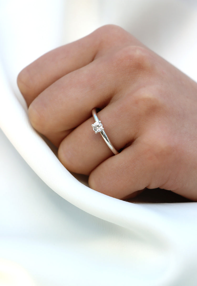 Tjej som bär en förlovningsring i silver med diamant.