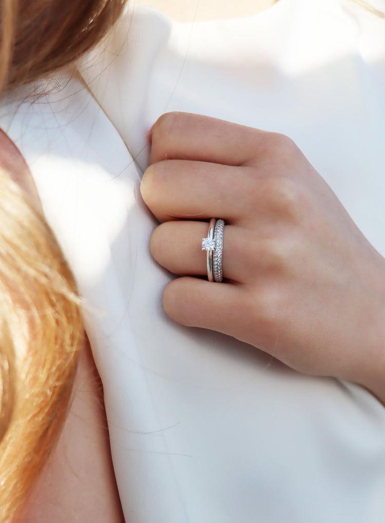 Tjej som bär set med vigsel och förlovningsringar med diamanter.