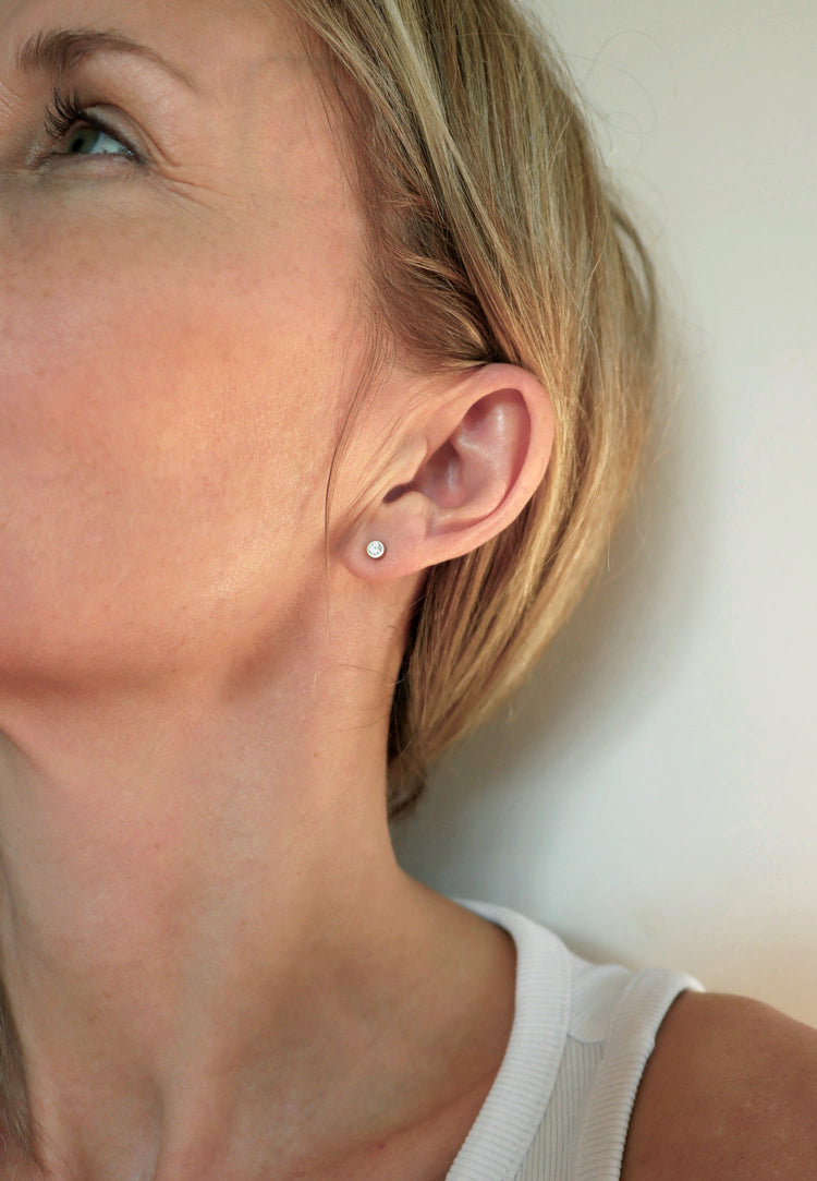 Tjej som bär små diamantörhängen i silver