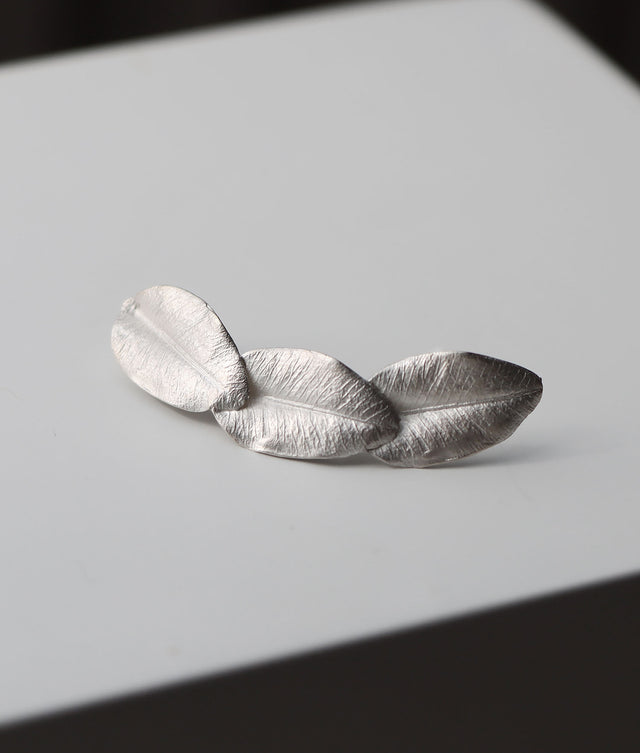 Tre silverblad ihopsatta till ett örhänge.