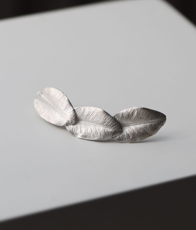 Tre silverblad ihopsatta till ett örhänge.