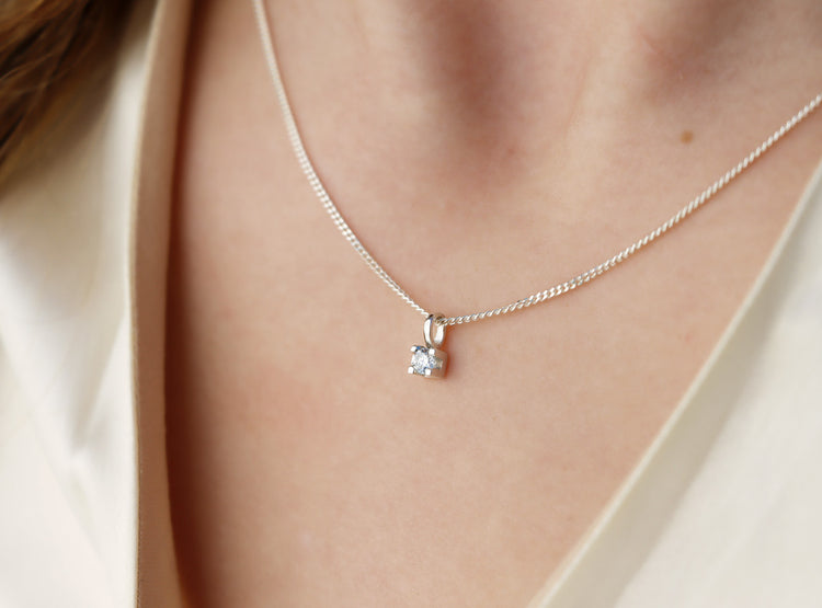 tjej som bär ett diamanthalsband i silver.