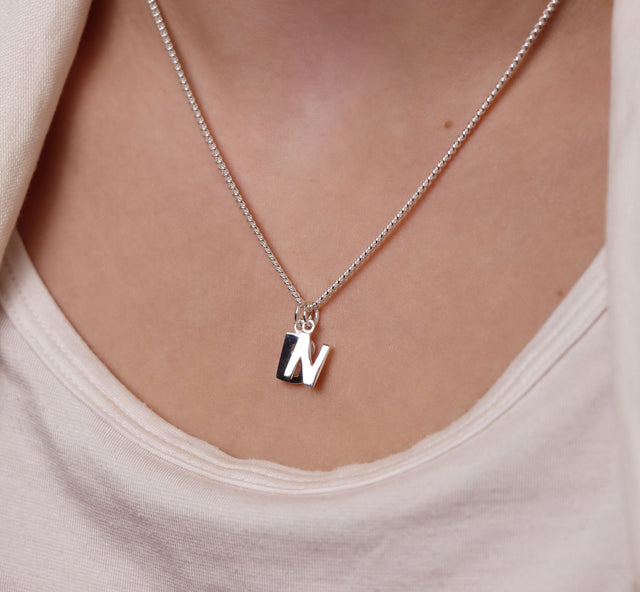 Halsband med bokstavsberlock i silver.
