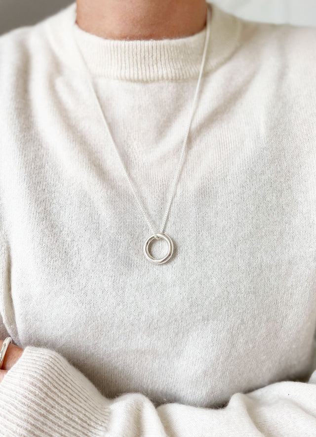 Tjej som bär en silverring som halsband i kedja.