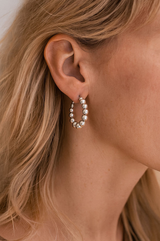 Örhängen med ringar och silverkulor på en tjej.