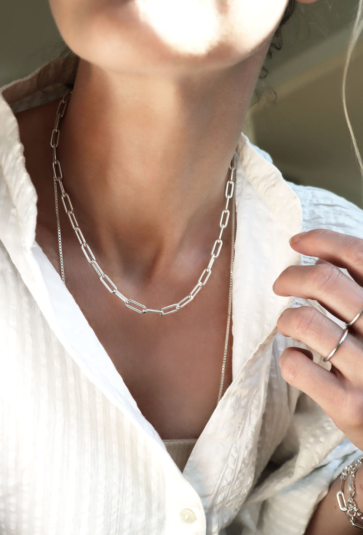 Tjej som bär ett kedjehalsband i silver.