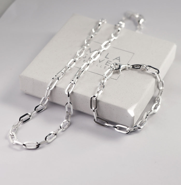 Ett halsband och ett armband av kedjor som ligger på en vis smyckesask.