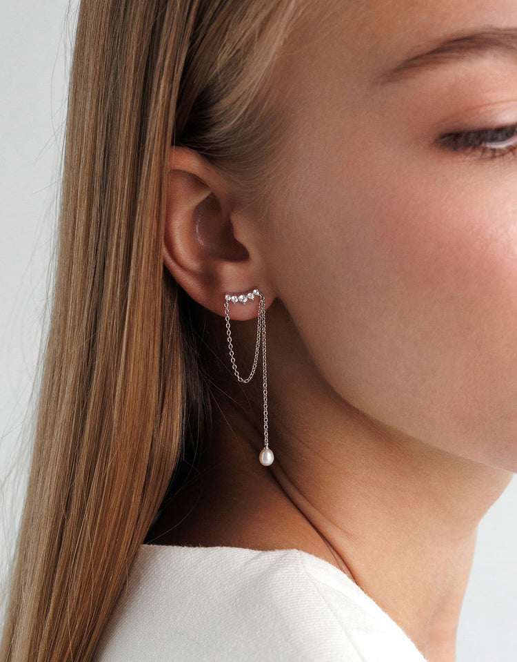 Örhängen med kedjor och hängande pärlor.