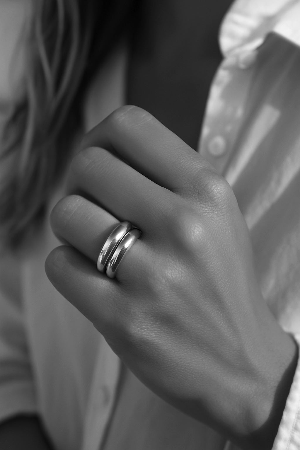 Tjej som bÀr en ring stack med tvÄ tjocka silverringar.