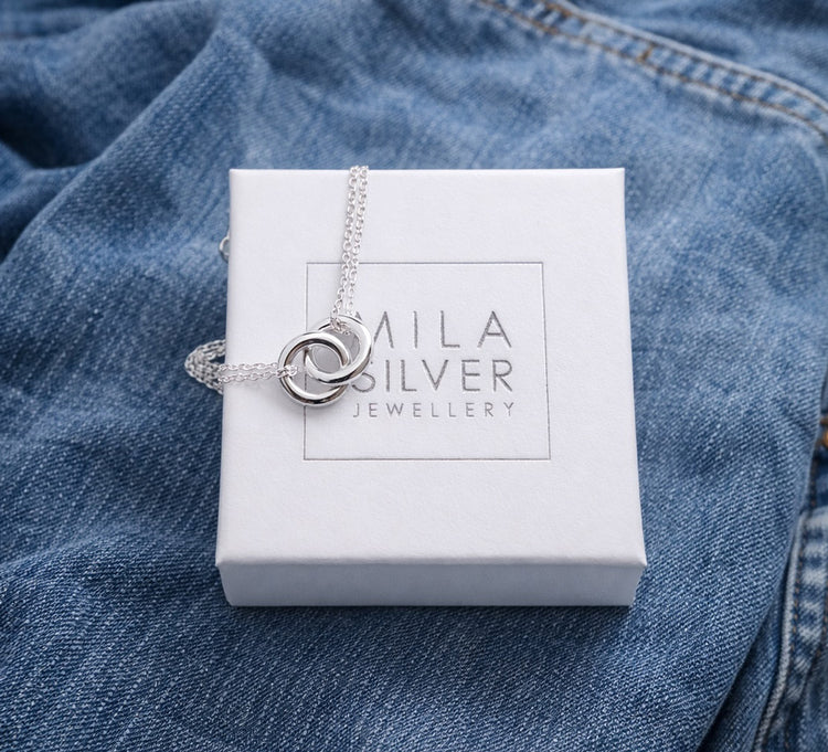 Silverarmband med ringar placerade på en vit ask från Mila silver