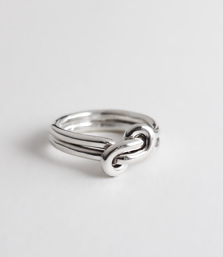Silverring med dubbla ringar som förenas i en evighetsknut