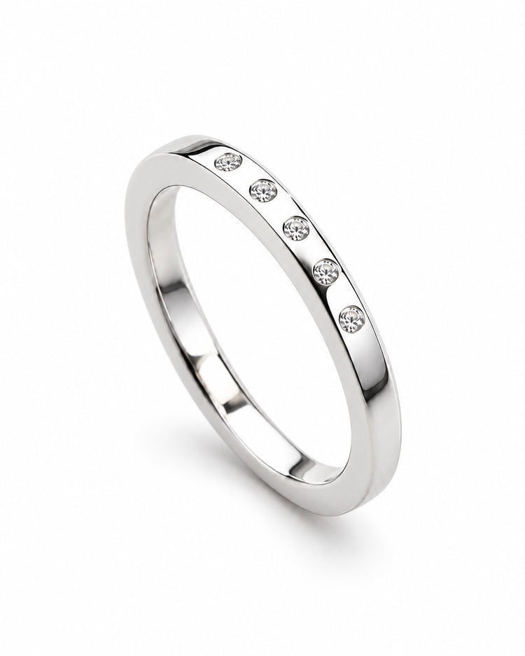 Silverring med en fem diamanter på rad som sitter i ringen.