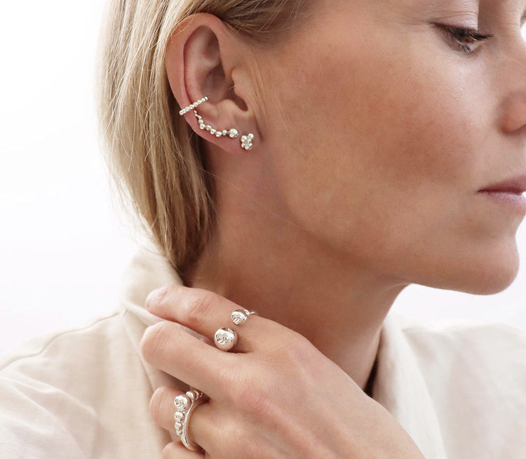 Tjej som bär flera örhängen i samma öra.