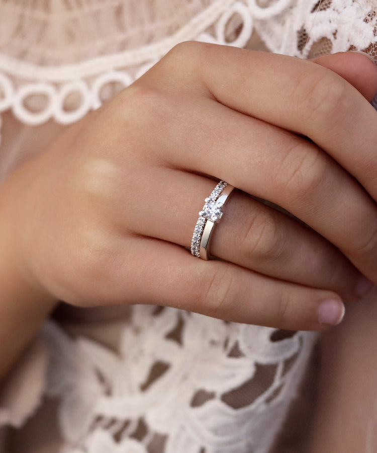 Tjej som bär ett set med diamantringar som vigsel och förlovningsringar. Diamantringar i silver med enstensring 0,25 ct och alliansring.