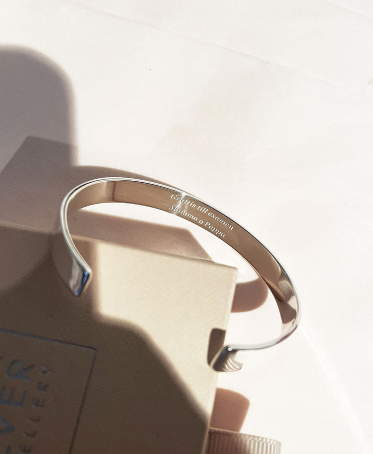 Silverarmband som är graverat på insidan.
