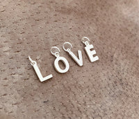 Bokstavsberlocker i silver som skapar ordet LOVE