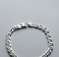 Närbild på låset på ett armband med silverkedja