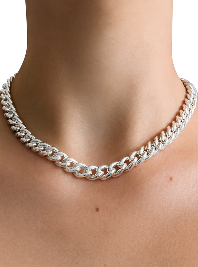 Tjej som bär ett chunky kedje halsband i äkta silver av modell Pansar. 