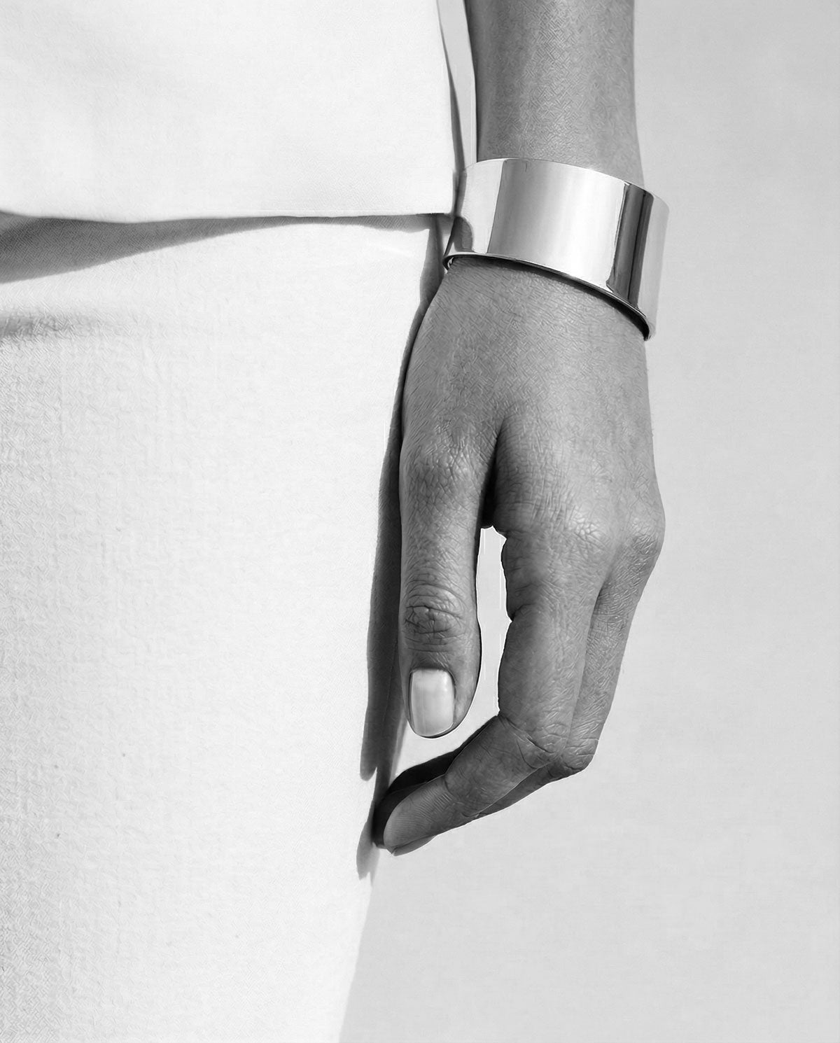 Kvinna som bär ett brett cuff armband i blankt äkta silver - 925 silver.