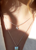 Tjej som bär ett halsband med bokstavsberlock i silver med diamanter