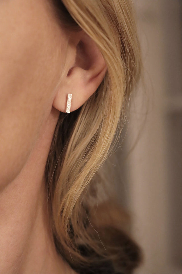 Kvinna som bär örhängen med diamantstavar