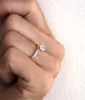 Diamantring med 0,5 ct stor diamant, sedd från sidan. Diamanten sticker upp från ringen i kron-fattning. 