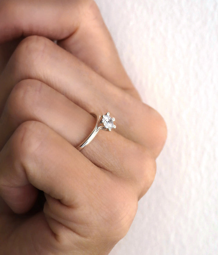 Diamantring med 0,5 ct stor diamant, sedd från sidan. Diamanten sticker upp från ringen i kron-fattning. 
