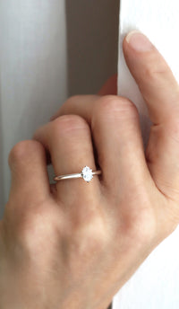 Kvinna som bär en vigselring eller förlovningsring i silver med oval diamant 0,5 ct. 