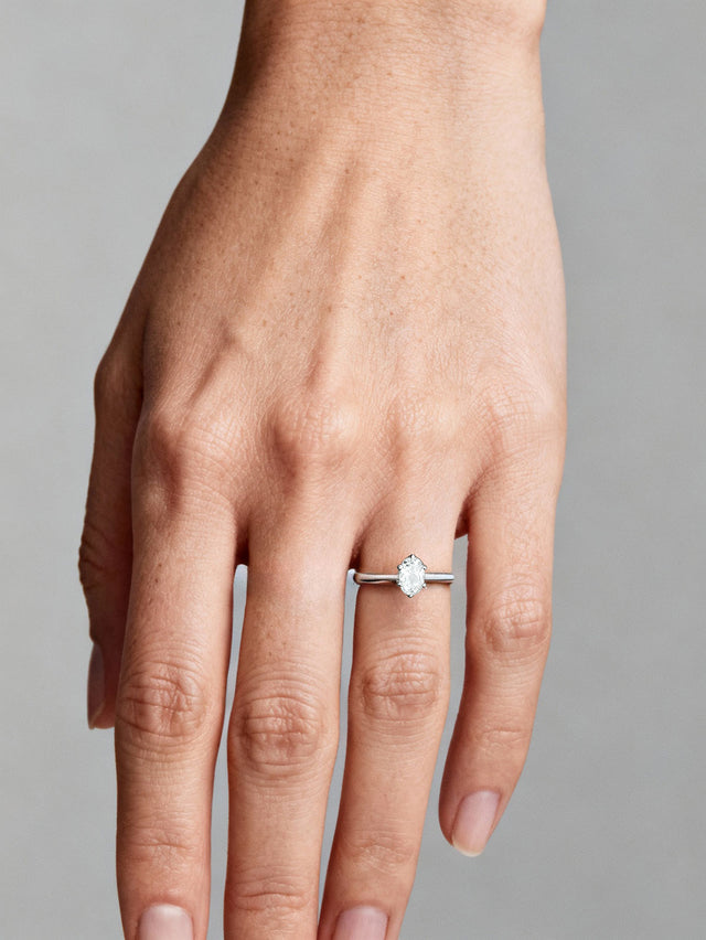 Kvinna som bär en förlovningsring med oval diamant 0,5 ct. 