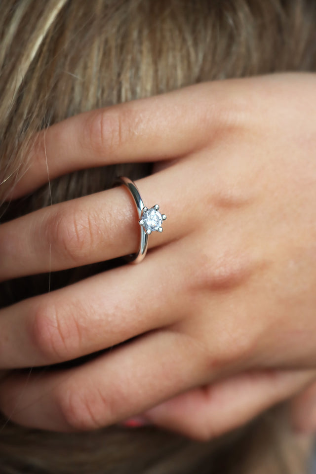 Tjej som bär en solitärring  / diamantring med stor diamant. 