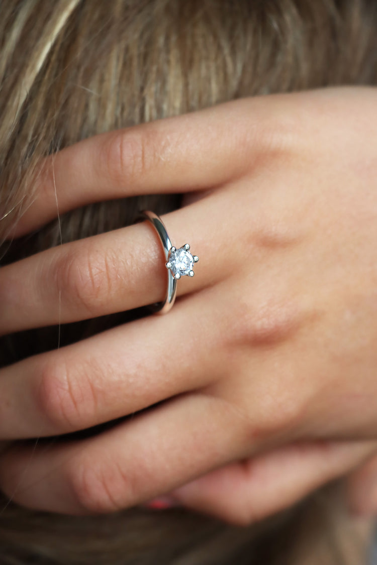 Tjej som bär en solitärring  / diamantring med stor diamant. 