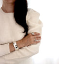 Tjej som bär ringar med stora silverkulor och ett brett cuff armband i silver.