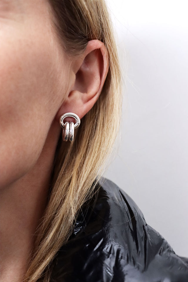 Silverörhängen med länkade ringar på en kvinna