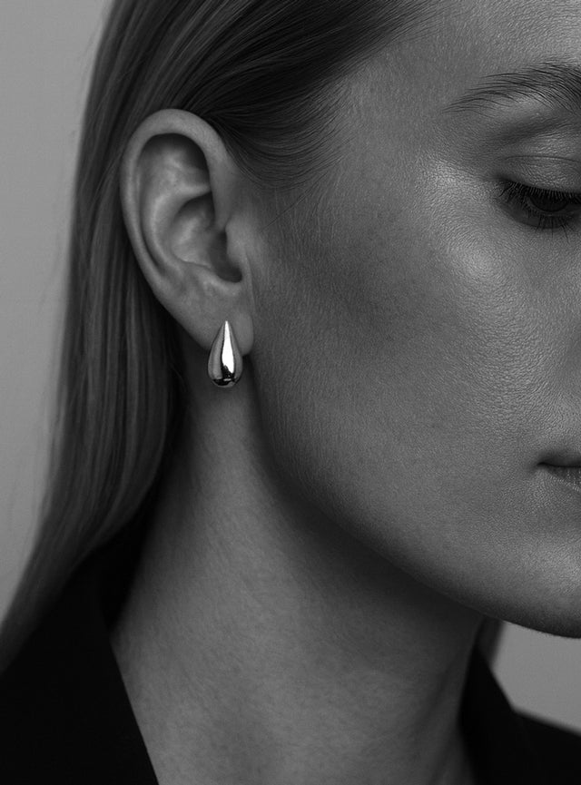 Kvinna som bära eleganta silverörhängen med stora droppar i äkta silver. 