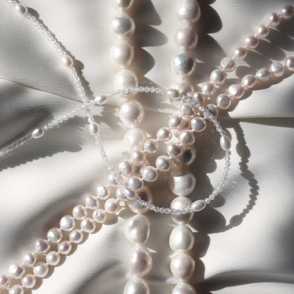 smycken med pärlor liggandes på vitt tyg