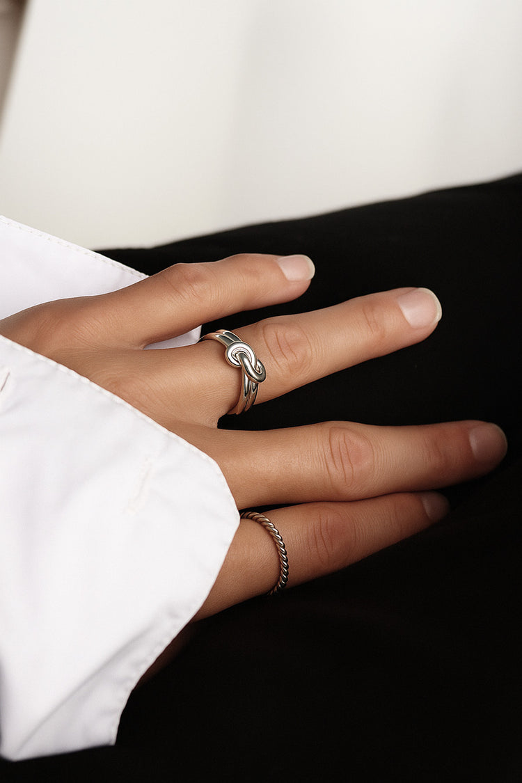 Tjej som bär en silverring med eternity knut.