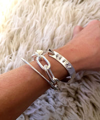 Tjej som bär ett bredd kedjearmband med Paperclipkedja med ett cuff armband och bangle i äkta silver. 