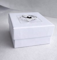 En ring i silver med ett hjärta placerad på en vit ask från Mila Silver. 