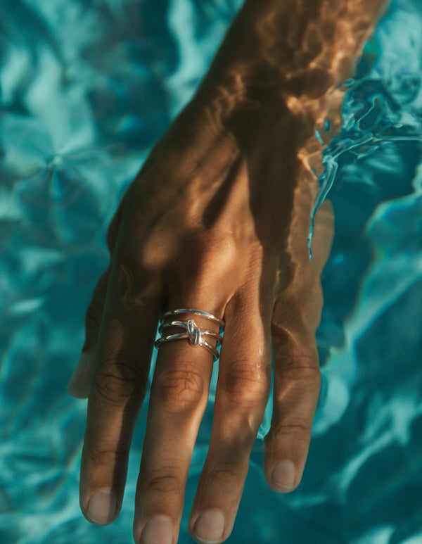 Silverring på hand som är under vattnet.