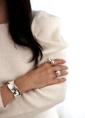 Tjej som bär ringar med stora silverkulor och ett brett cuff armband i silver.